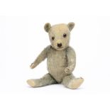 A 1930s blue mohair Chiltern-type teddy bear, with orange and black glass eyes, pronounced clipped