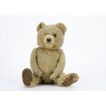 A post-war Chiltern Ting-a-Ling type teddy bear, with beige mohair, one orange and black glass eyes,