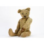 An early British teddy bear 1910-20s, with blonde mohair, small black boot button eyes, pronounced