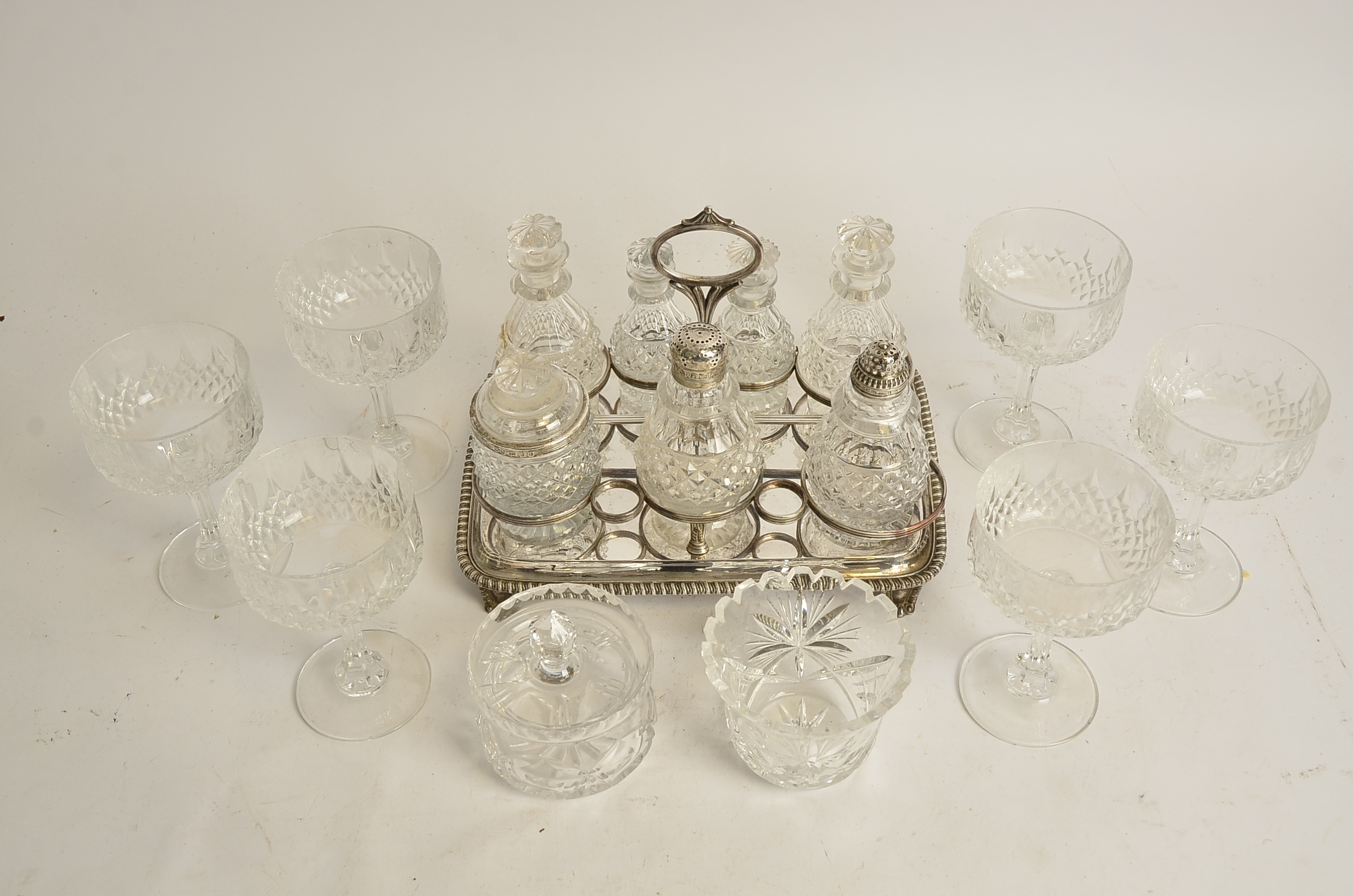 A seven part cruet set on plated stand, with a Georgian pierced silver lid, hallmarked for Sheffield