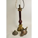 A 19th Century gilt brass lamp base, with cranberry glass central column, raised on a scrolling