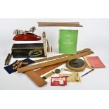 A collection of measuring instruments, including a lawn tennis measure, a brass tape measure, a 19th
