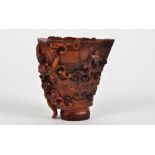 An early 20th Century Chinese carved horn libation cup, the design with multiple raised crawling