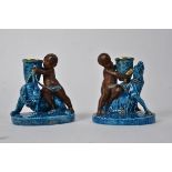 A pair of Worcester turquoise figural candlesticks, with bisque cherubs and glazed baskets supported