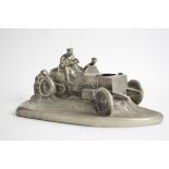 A heavy sculptural cast desk object taking the form of early motor car, with space for an inkwell,