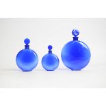 René Lalique (French, 1860-1945) a graduated set of three blue glass circular Worth perfume bottles,