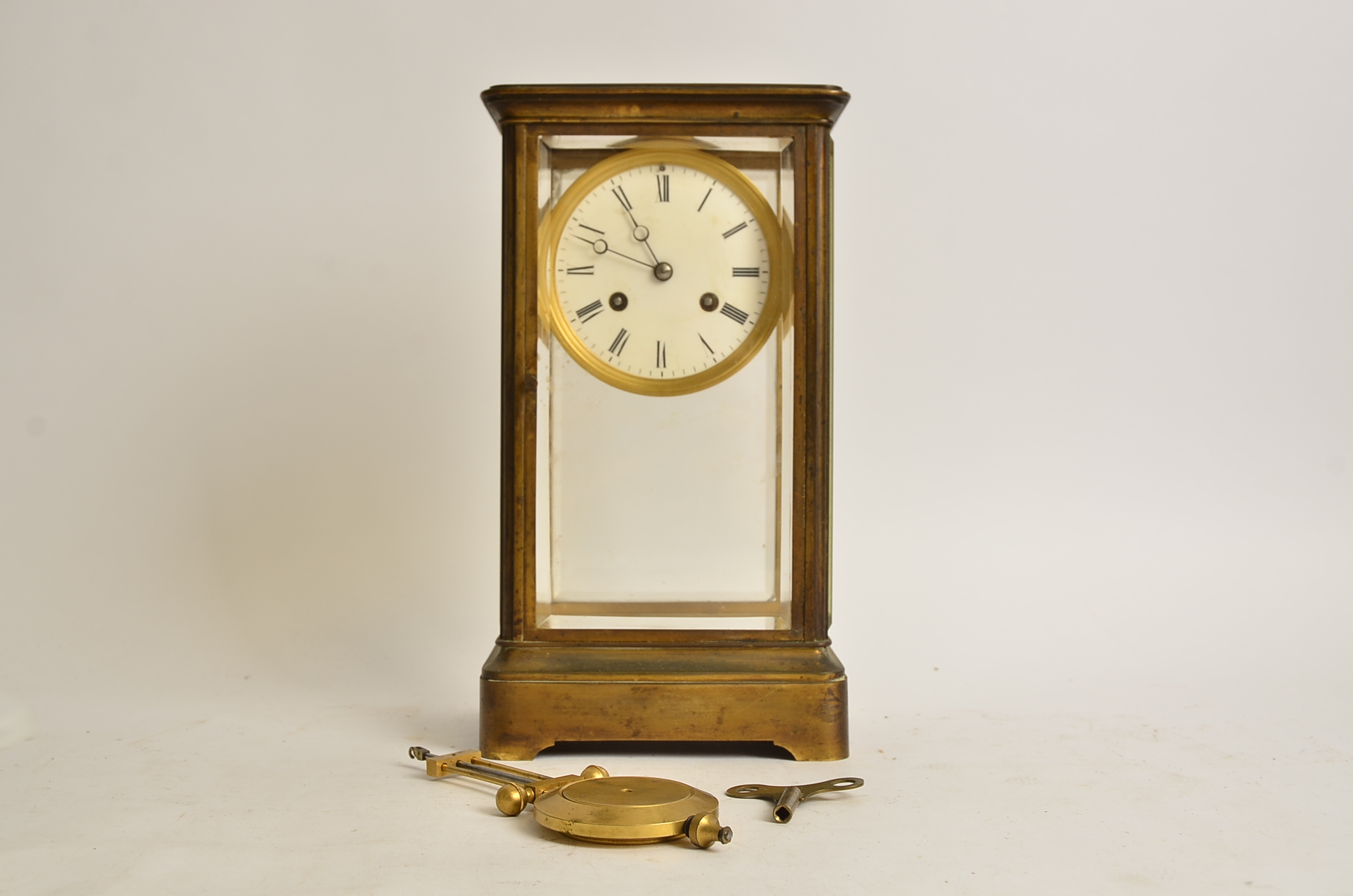 A brass four-glass mantel clock, with Roman numerals and enamel dial, height 30.5cm