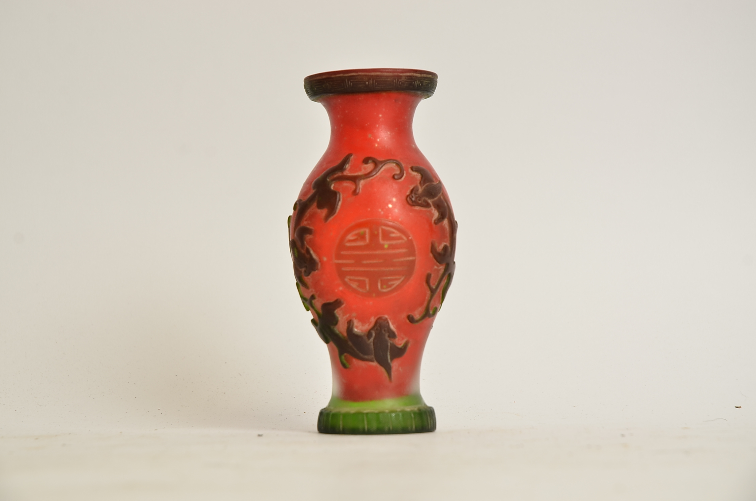 A Chinese red cameo glass vase, with encircling dragons and shou characters, height 15cm