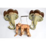 A pair of elephant wall mounts, 36cm x 27cm x 13.5cm, together with an elephant puppet (3)
