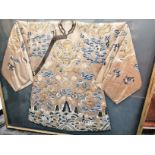 A framed and glazed 19th Century embroidered Chinese court robe, on a beige ground, of symmetrical