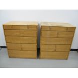 A matching pair of Cotswold School style chest of drawers oak frames with panelled sides and tops,