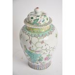 A Chinese covered jar with Famille rose decoration, with lotus panels, rising to a study of birds