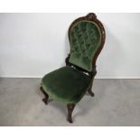 A Victorian walnut framed button backed nursing chair foliate decorated carved frame, raised on
