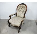 A Victorian walnut framed spoon back open arm chair, the shaped show wood frame carved with leaf