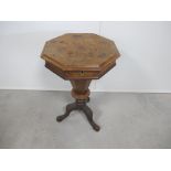 A Victorian octagonal walnut sewing table, with moulded rising top, raised on a carved tripod