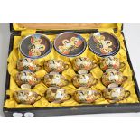A cased set for twelve persons of early 20th Japanese polychrome china, with a design of male and