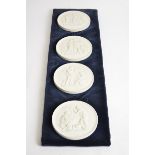 Four Royal Copenhagen bisque roundels with classical subjects, width 14cm, all hung on a mount, 69cm