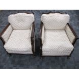 A pair of early 20th century mahogany framed arm chairs, shaped back rails and scroll arms, raised