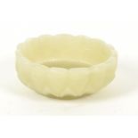 An Indian jade circular dish, the exterior carved with a row of petals emerging from the bud beneath
