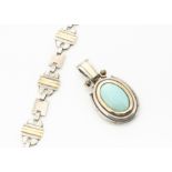 A contemporary silver and gold oval turquoise drop pendant, centred with cabochon turquoise pebble