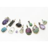A collection of hardstone pendants, including three turquoise set in silver, an amethyst matrix in