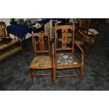 An Arts and Crafts oak armchair, with pierced back splat and back rail above a later floral