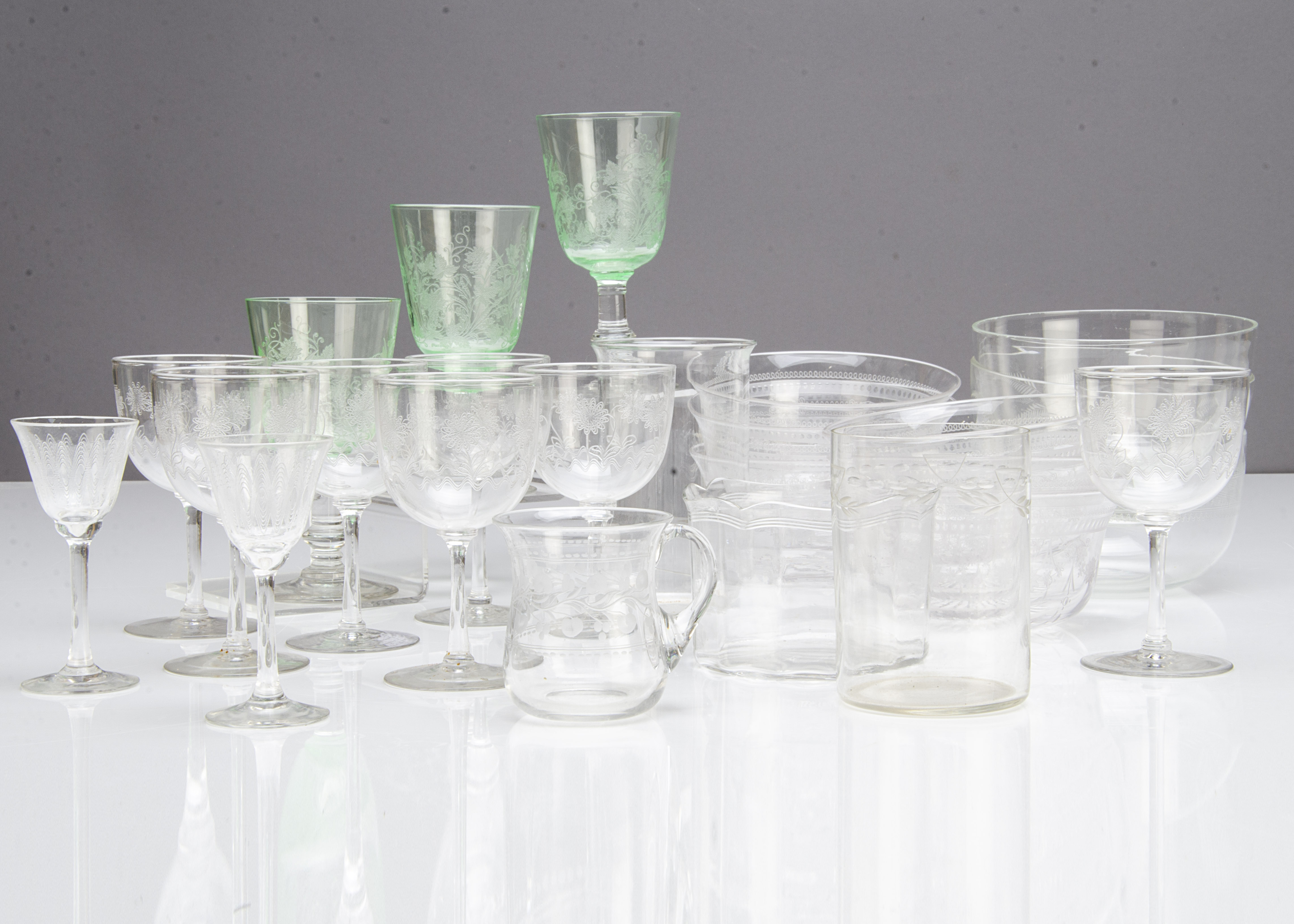 A collection of Edwardian etched glassware, including seven sherry glasses with floral design, three