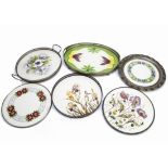A collection of early 20th Century continental pottery and base metal trays and platters, each