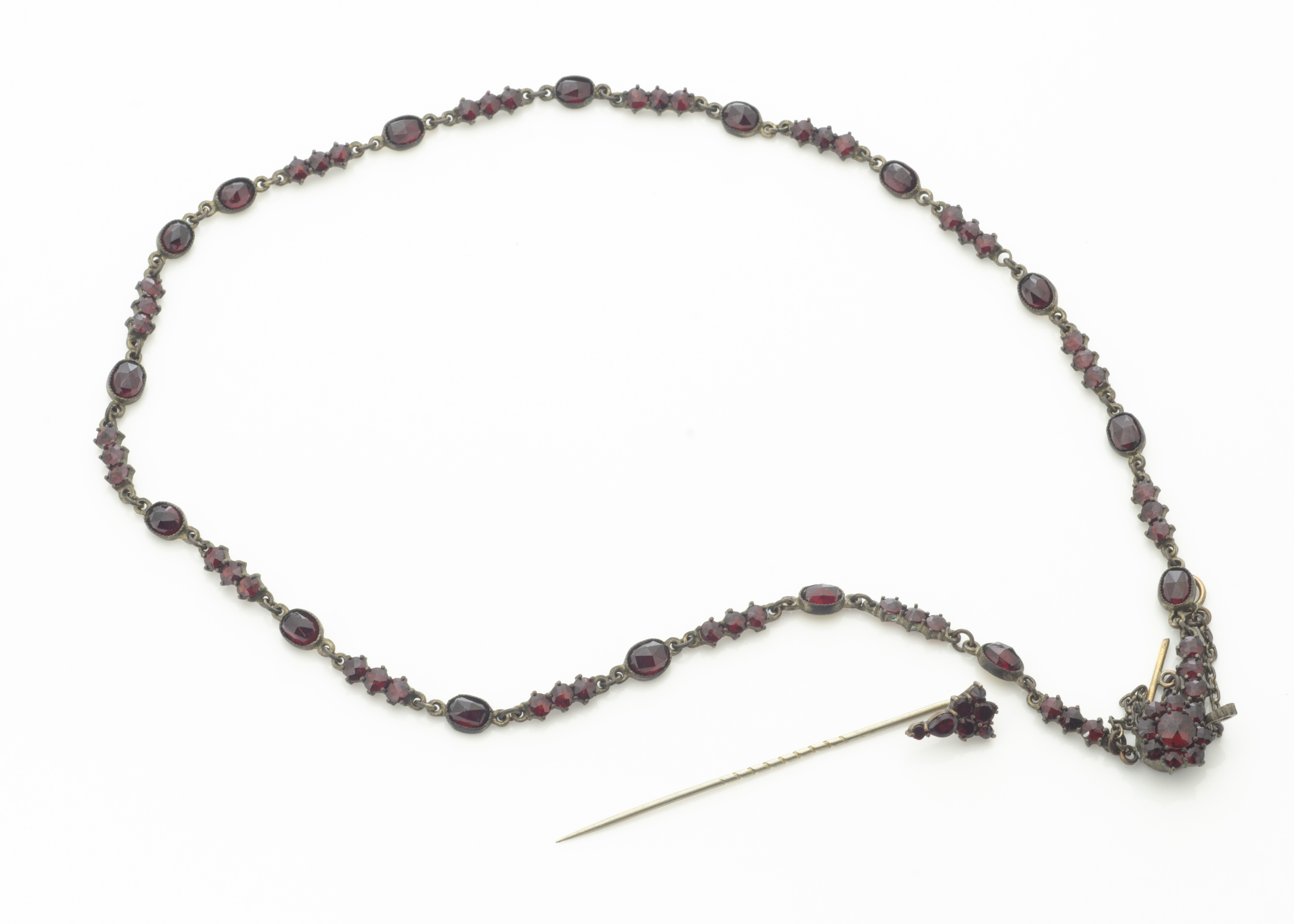 An early 20th Century foil backed continental garnet necklace, oval and circular faceted in claw and - Image 2 of 2