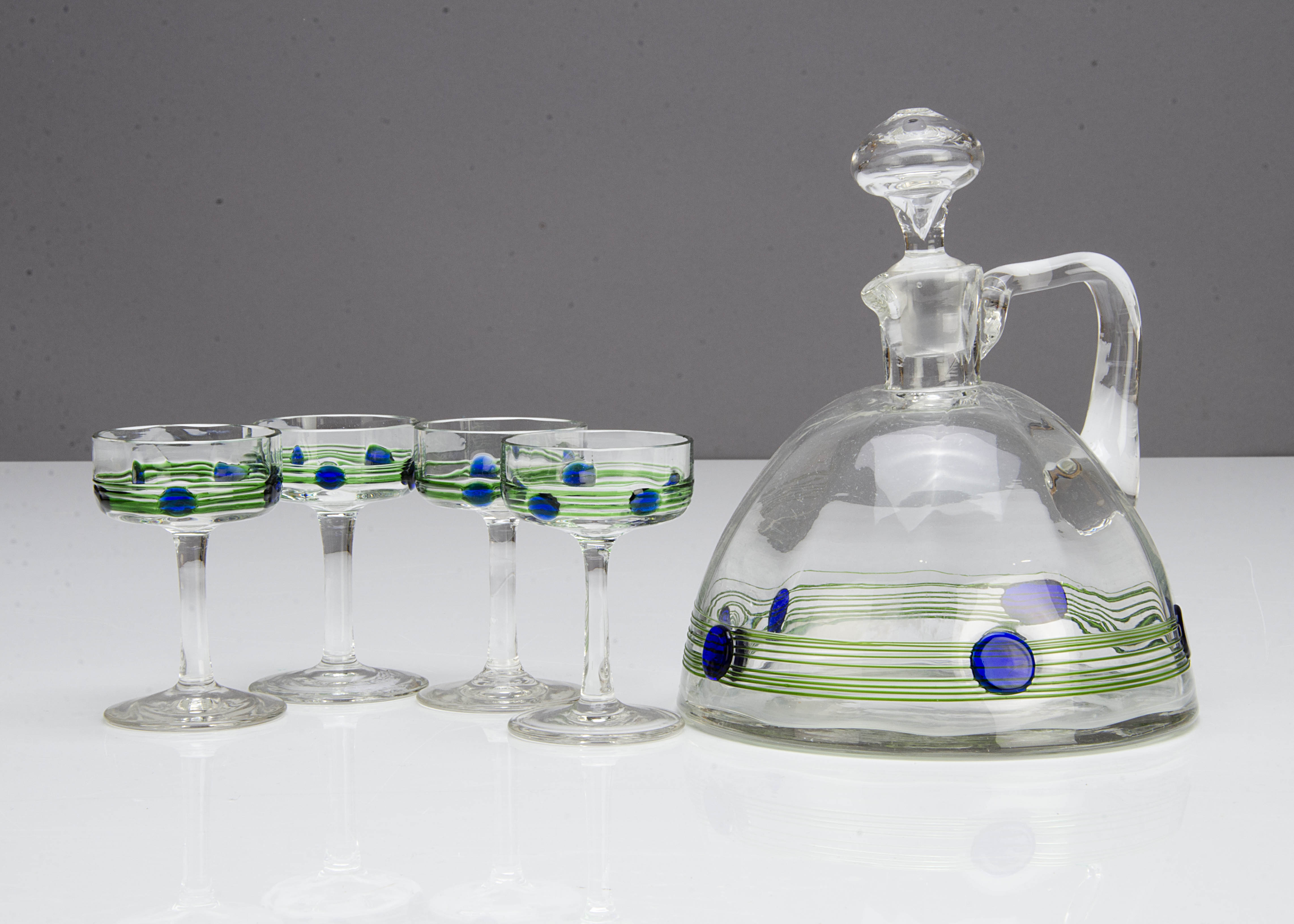 A Powell & Sons glass liquor set, comprising a conical tankard and four shallow bowled stemmed