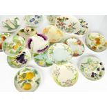 A collection of St Clement and Sarreguemines majolica plates, including a set of ten fruit and