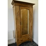 An Art Nouveau satin walnut single wardrobe, with mirrored bevelled arched door above a base