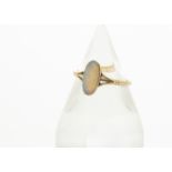 An 18ct gold opal dress ring, the elongated precious oval opal in rubbed over setting with pierced