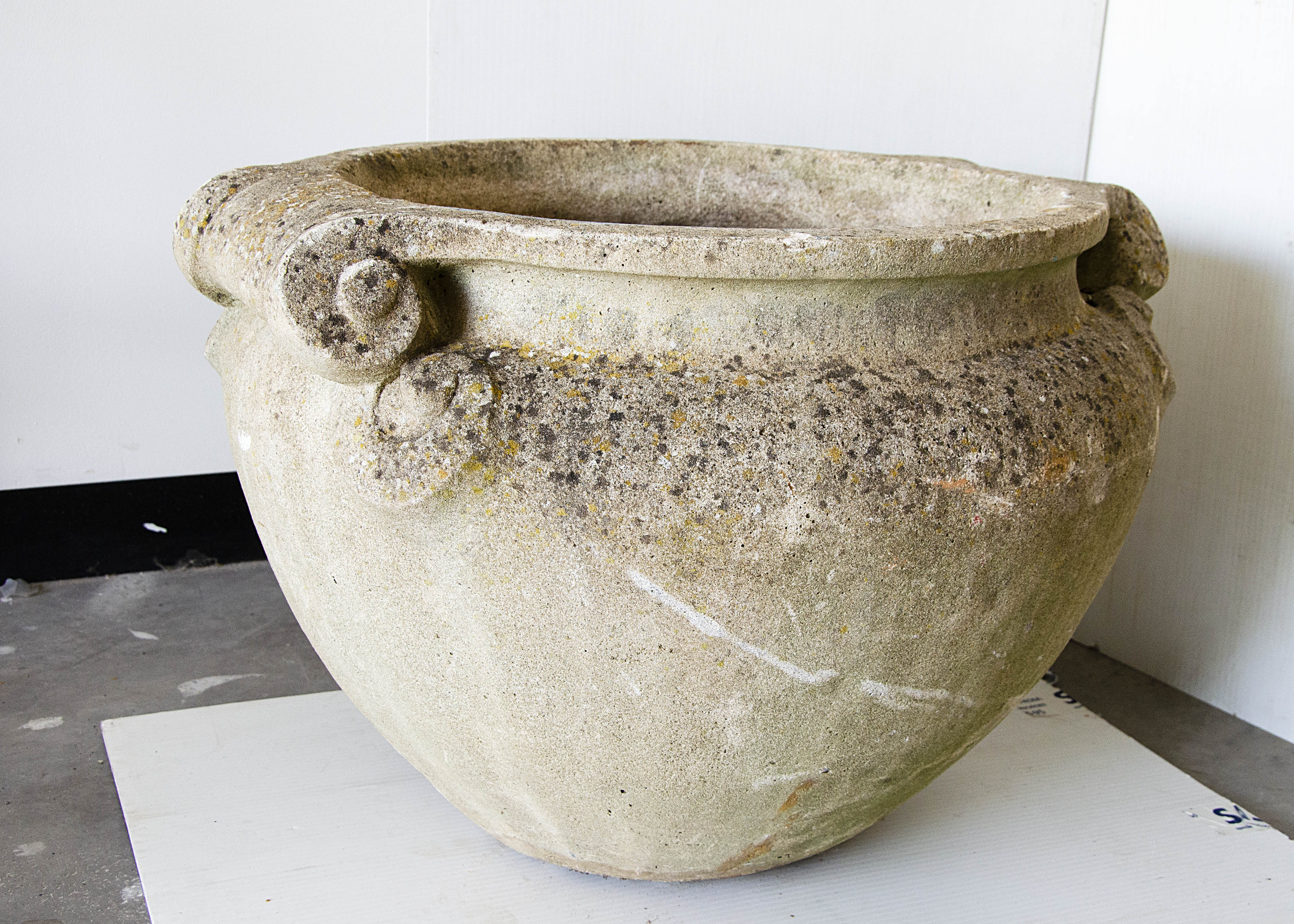 A large concrete planter, of circular tapered design with scroll twin handles, large open