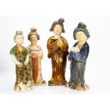 Four Chinese earthenware female tomb figures, in the Tang dynasty style, modelled standing, one with