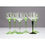 A set of four continental Art Nouveau green wine glasses, the circular bowls with waisted and