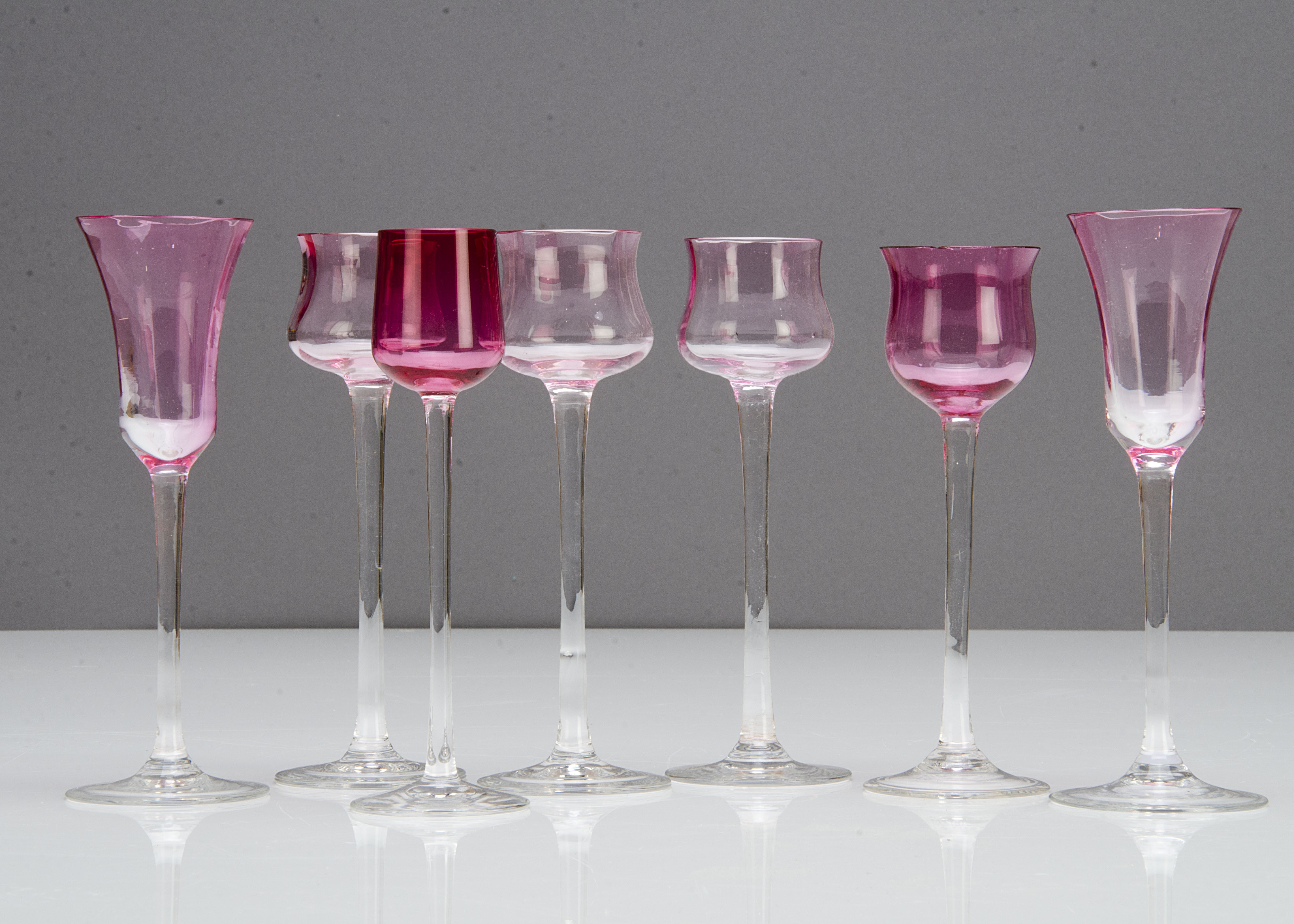 A set of four German Art Nouveau tulip liquor glasses with pink bowls and colourless stems, 15cm