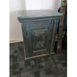 A continental blue painted cabinet, the hinged door with stylised floral carved decoration opening