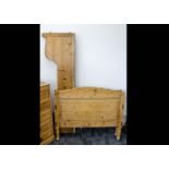 A continental pitch pine single bed, with shaped sides and head and foot boards, 117cm wide x 95cm