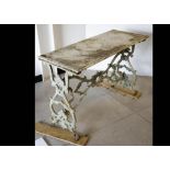 A marble topped garden table, the rectangular marble top supported on a cast iron frame of bracket