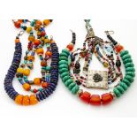 A collection of North African and Middle Eastern coloured bead necklaces, including a white metal