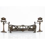 A pair of Art Nouveau fire dogs, the cast iron fire dogs with stylised flower head design on