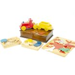 A wooden child's carpet train, by Escor, in red and yellow together with various wooden puzzles