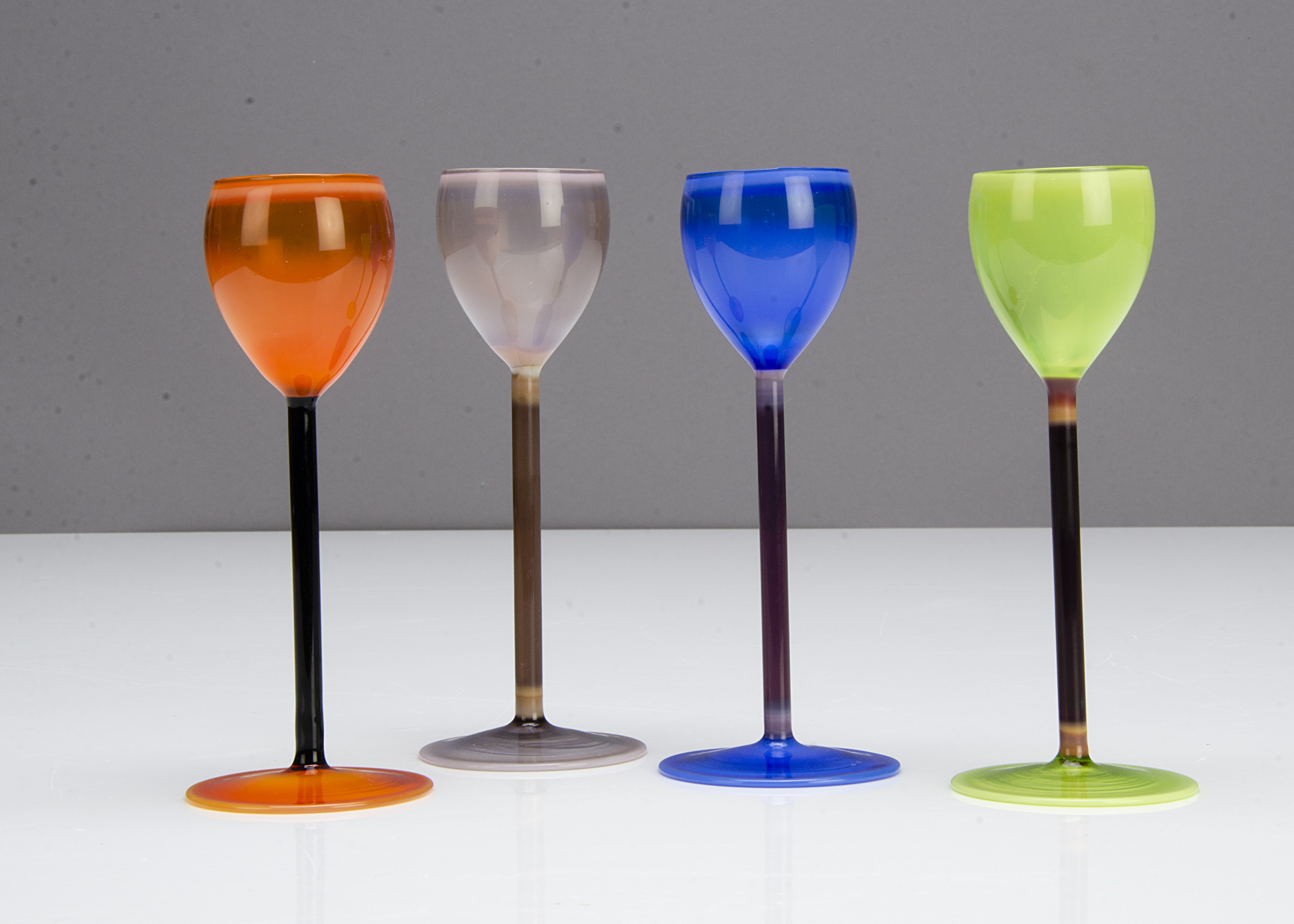 A set of four continental harlequin coloured Vaseline liquor glasses, in orange, green, blue and - Image 2 of 2
