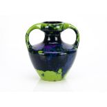 A continental stoneware twin handled vase, the mauve, blue and green drip glaze on a circular body