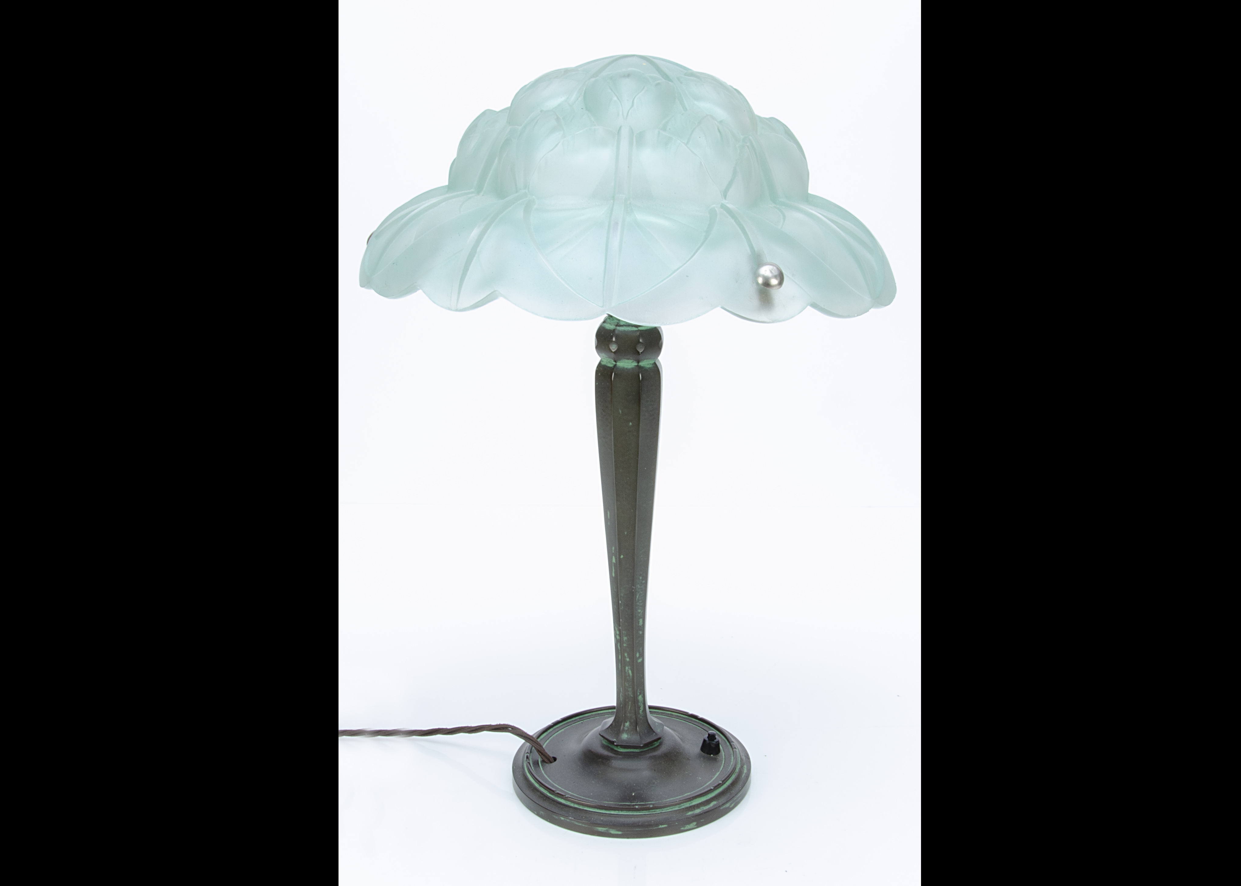 A continental Art Deco bronze and frosted glass table lamp, the circular base supporting a faceted