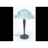 A continental Art Deco bronze and frosted glass table lamp, the circular base supporting a faceted