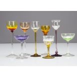 Two shallow bowl liquor glasses, one in amethyst the other in green with colourless glass stems