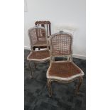 A pair of continental painted and caned back single chairs, the distressed paintwork to the carved