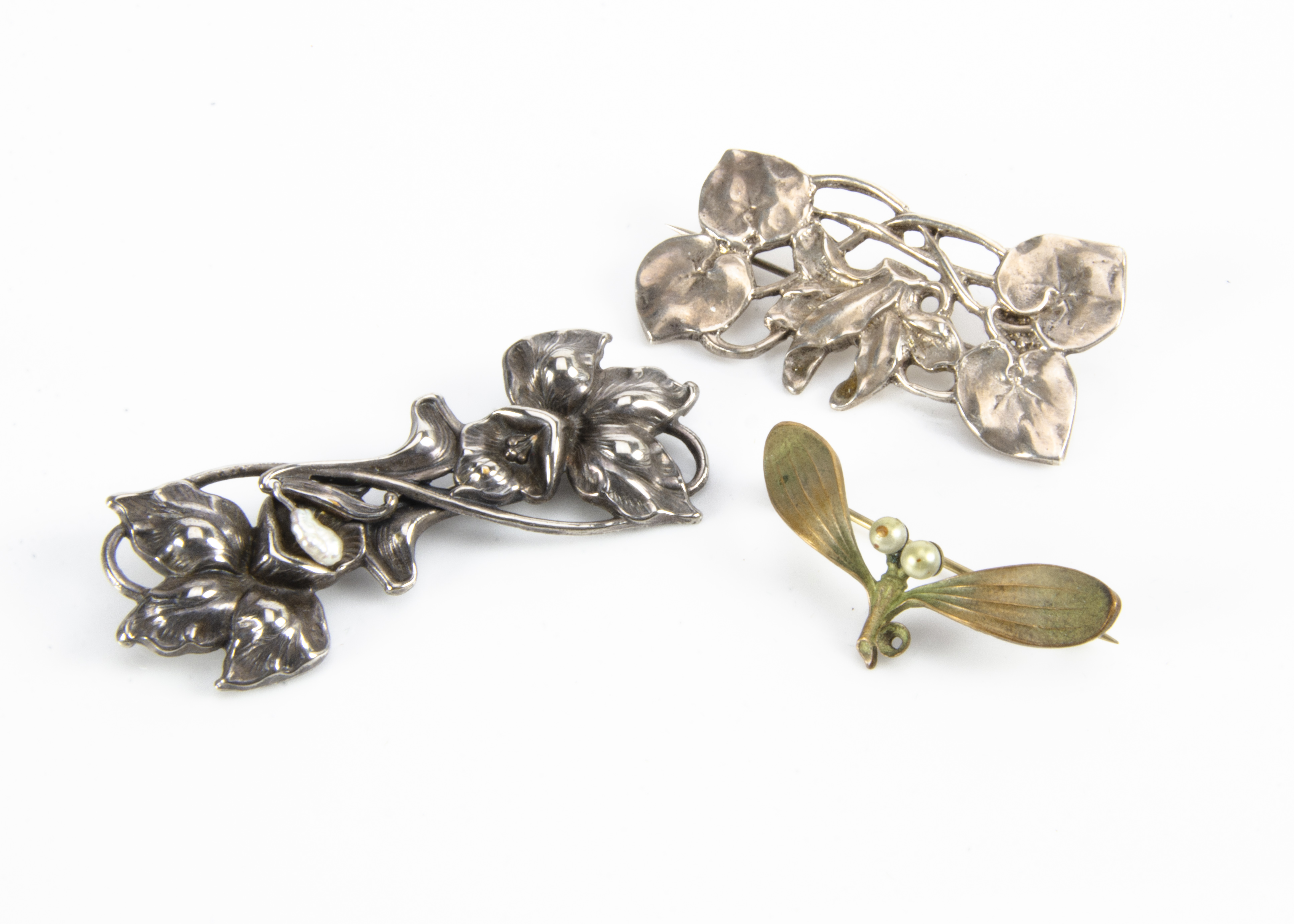 Two white metal floral brooches, one with daffodil design, the other with stylised flower head and